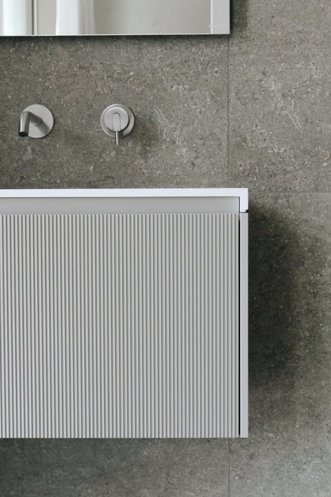 Designer large format tiles cladding a stylish bathroom wall