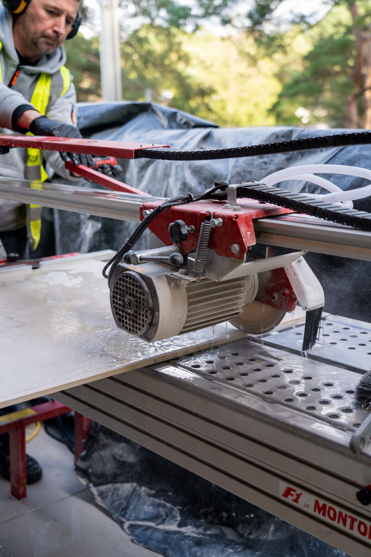 Montolit F1 wet tile saw cutting a large-format porcelain tile for a professional tile installation.