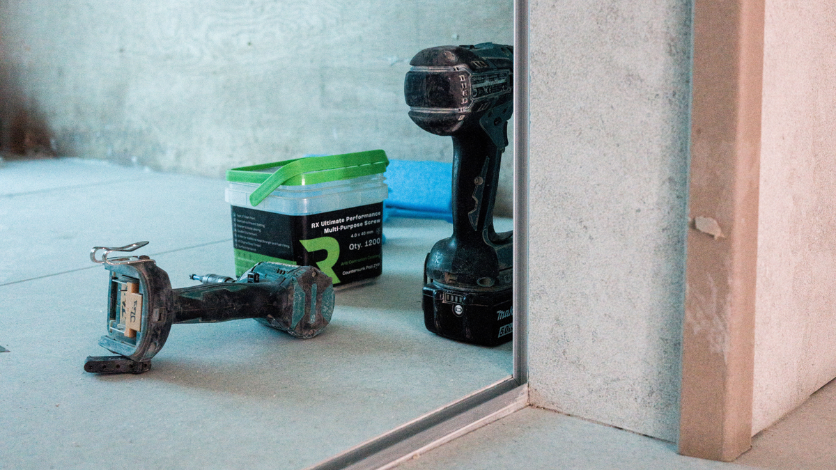 Professional tile installation tools for large-format porcelain tile fitting, including a suction lifter, power tools and construction adhesive.