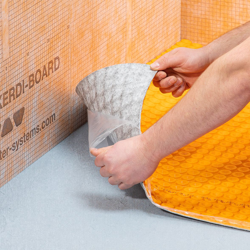 Person peeling adhesive layer off Schluter ditra heat duo ps mat