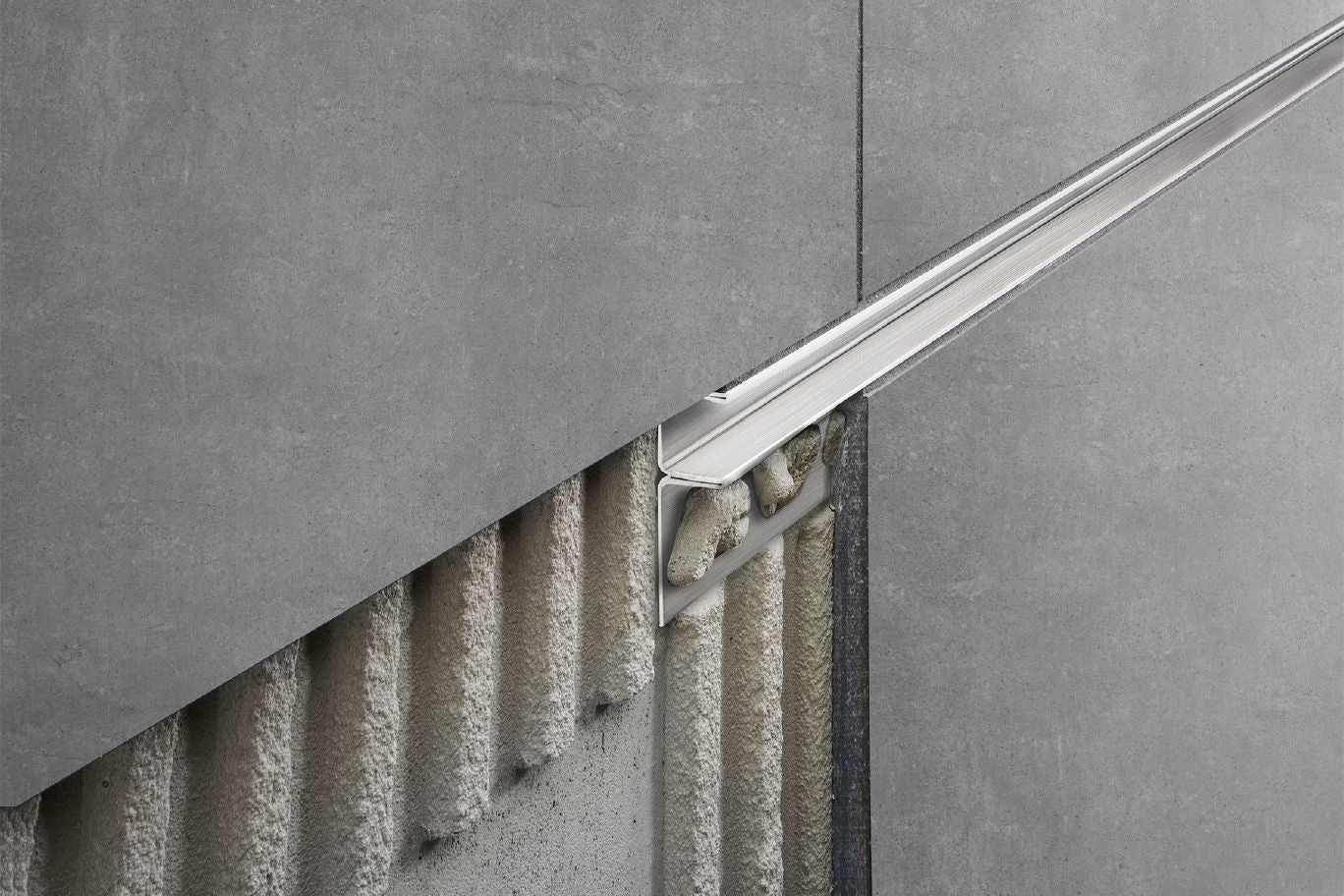 Schluter Decorative shower profile beside grey tiles